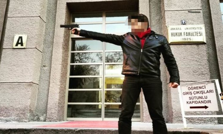 University assistant says photo of him holding a gun was 'meant to be a joke'