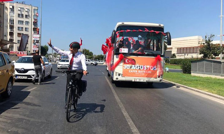 İzmir Mayor tours city on bike when barred from riding parade bus by governor