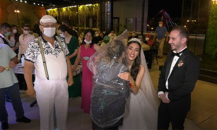 Woman wears plastic bag against COVID-19 at Black Sea wedding